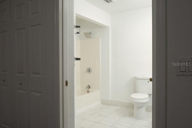 bathroom with tub / shower combination, toilet, and tile patterned flooring