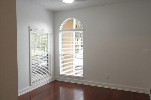 unfurnished room with dark wood-type flooring