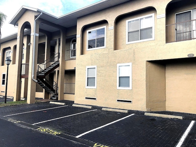 8846 Coral Palms Ct Unit A, Kissimmee, FL 34747 - view of building exterior with stairs and uncovered parking