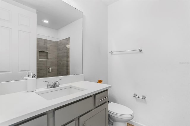 bathroom featuring toilet, vanity, and walk in shower