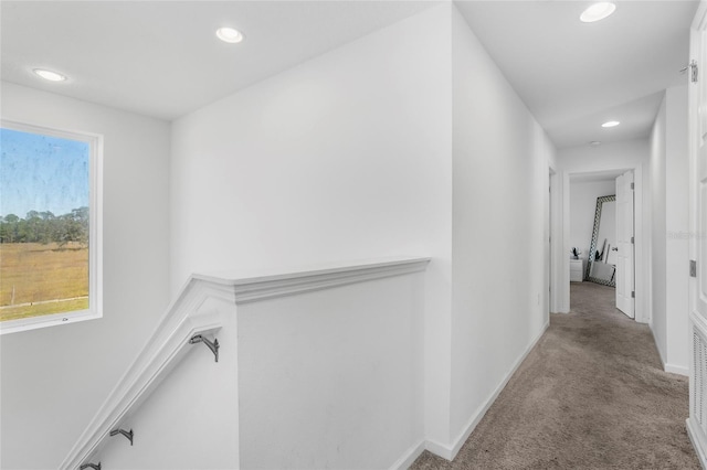 hallway featuring light colored carpet