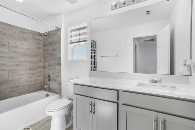 full bathroom with vanity, tiled shower / bath combo, and toilet