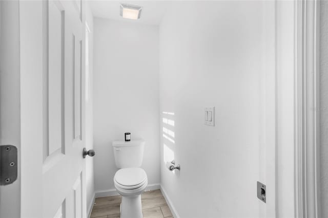 bathroom with wood-type flooring and toilet