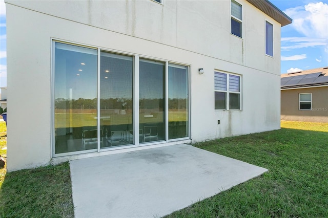 back of property with a yard and a patio