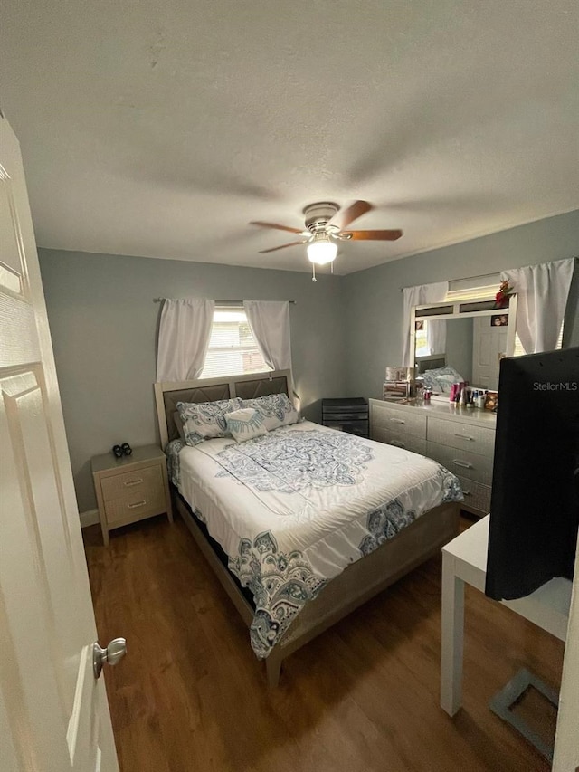 bedroom featuring a textured ceiling, dark hardwood / wood-style floors, and ceiling fan