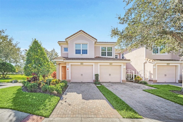 mediterranean / spanish home with a front lawn and a garage