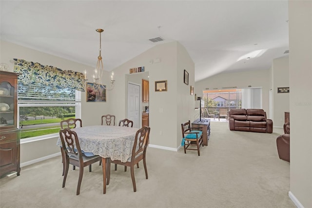 carpeted dining room featuring a chandelier, vaulted ceiling, and a wealth of natural light