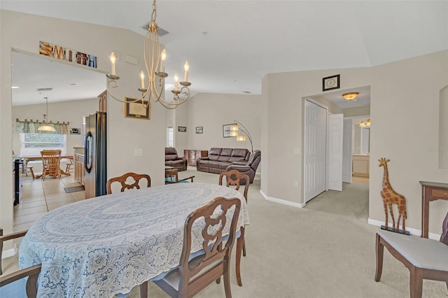 dining room with light carpet, a chandelier, and lofted ceiling