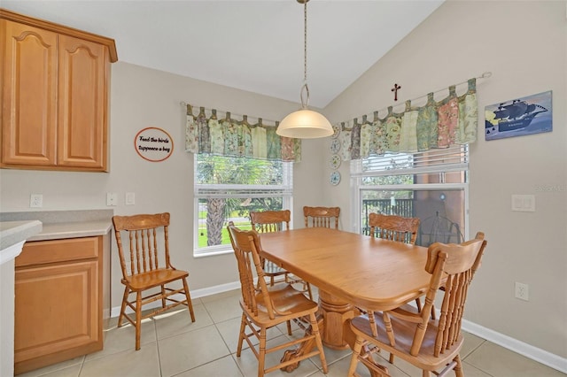 dining room with lofted ceiling and light tile patterned floors