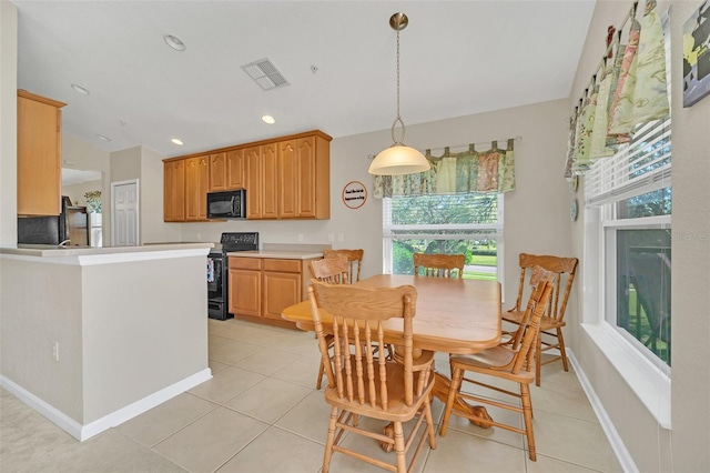 kitchen with kitchen peninsula, a healthy amount of sunlight, black appliances, and decorative light fixtures