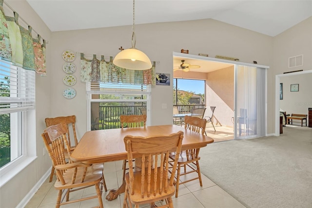 dining area featuring plenty of natural light, ceiling fan, light colored carpet, and vaulted ceiling