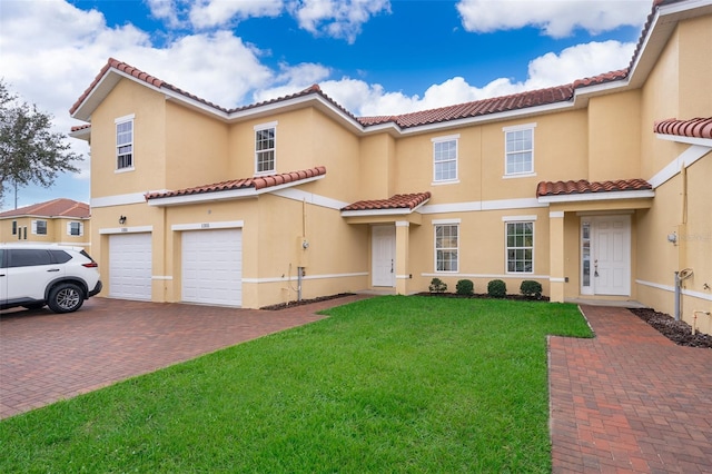 mediterranean / spanish home featuring a garage and a front lawn