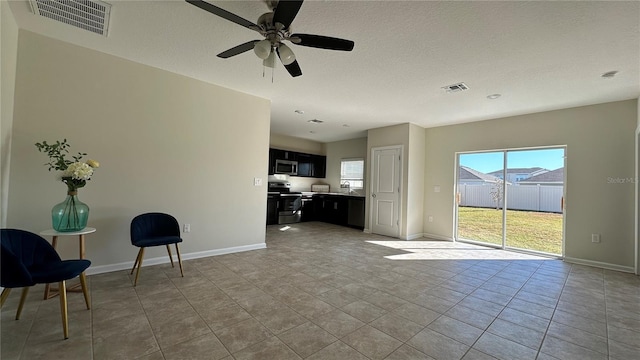 unfurnished living room featuring light tile patterned floors, a textured ceiling, ceiling fan, and sink