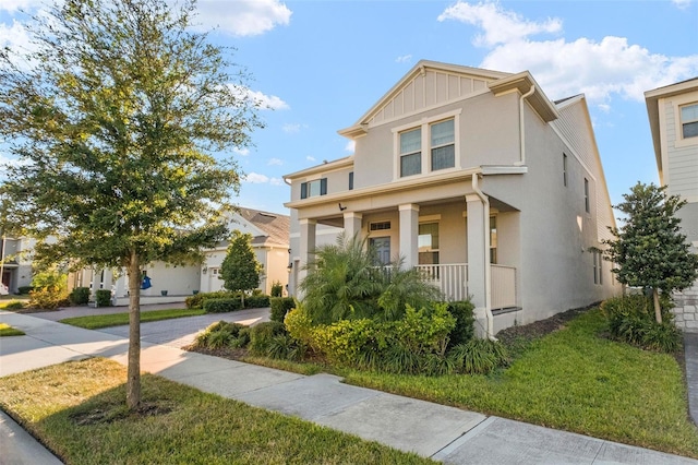 view of front of property featuring covered porch and a front yard