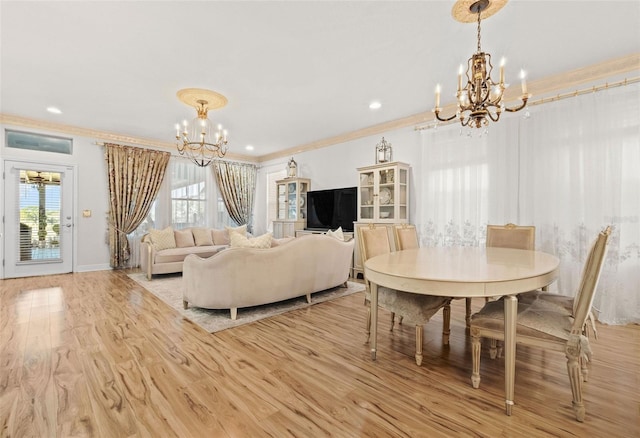 dining room with light hardwood / wood-style flooring, ornamental molding, and a notable chandelier