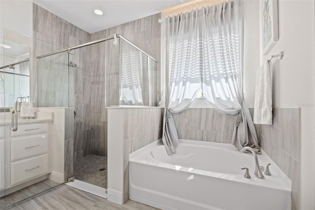 bathroom featuring shower with separate bathtub