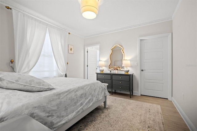 bedroom with light wood-type flooring and crown molding