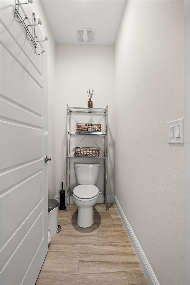 bathroom with toilet and hardwood / wood-style flooring