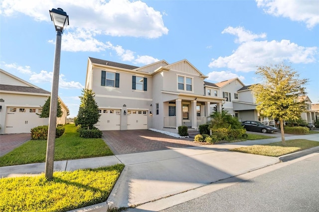 view of front facade featuring a front lawn, covered porch, and a garage