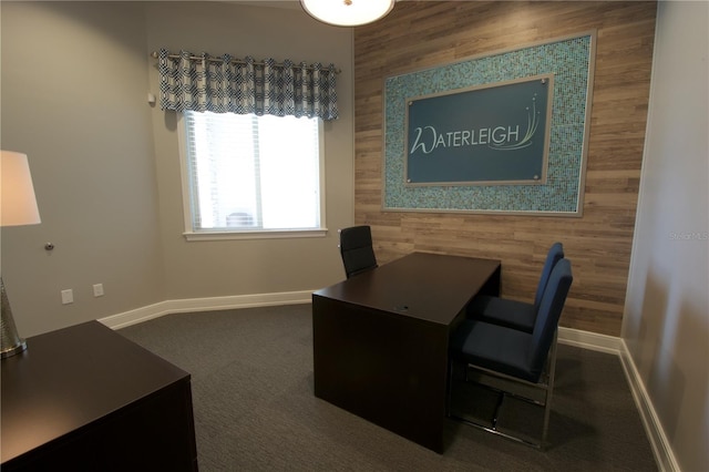 home office with wood walls and dark colored carpet