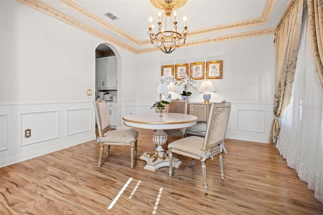 dining space with light wood-type flooring and an inviting chandelier