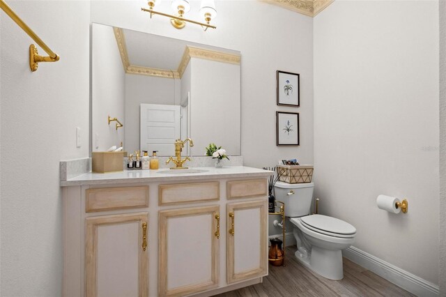 bathroom with hardwood / wood-style flooring, toilet, and vanity