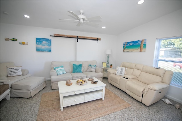 living room featuring ceiling fan, a barn door, light carpet, and vaulted ceiling