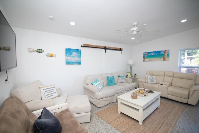 living room with a barn door and ceiling fan