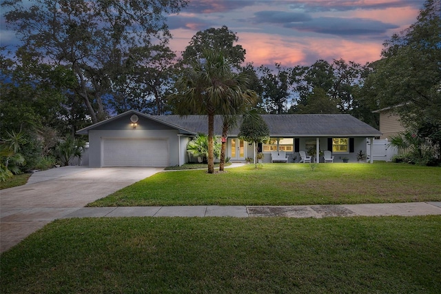 ranch-style house featuring a yard and a garage