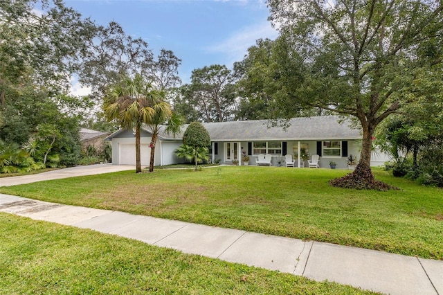 ranch-style home with a front lawn, a porch, and a garage