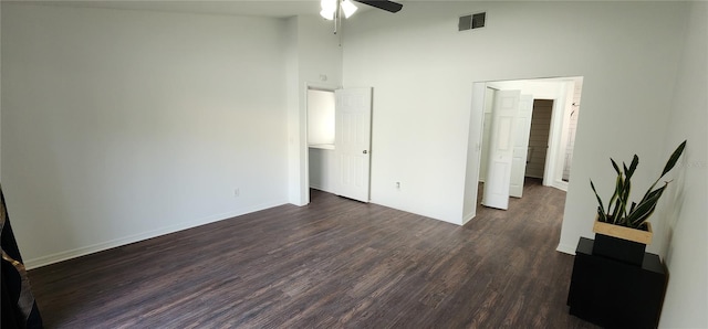 unfurnished bedroom featuring ceiling fan, a towering ceiling, and dark hardwood / wood-style floors