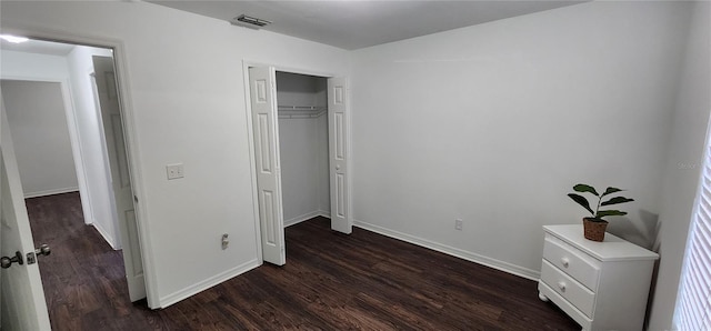 unfurnished bedroom with dark hardwood / wood-style flooring and a closet