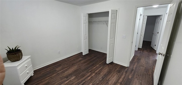 unfurnished bedroom featuring dark hardwood / wood-style flooring and a closet