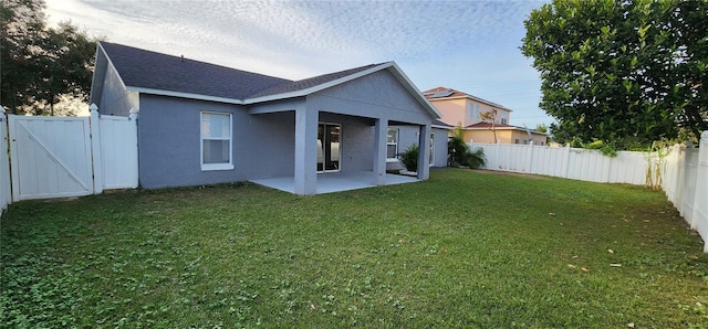 rear view of house featuring a patio area and a yard