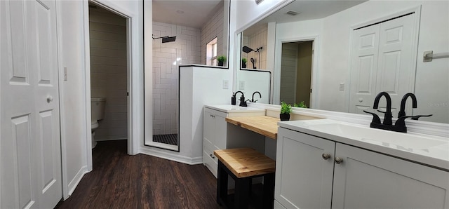 bathroom featuring hardwood / wood-style floors, vanity, toilet, and walk in shower