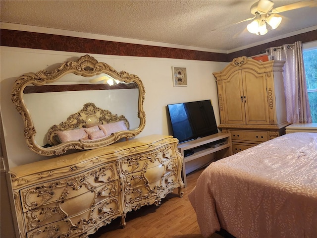 bedroom featuring a textured ceiling, light hardwood / wood-style floors, ceiling fan, and ornamental molding