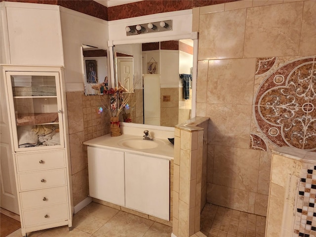 bathroom with a shower, tile patterned flooring, vanity, and tile walls