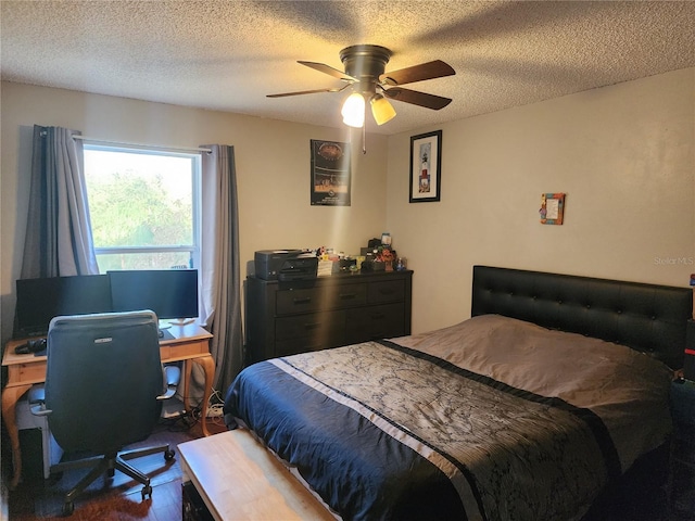 bedroom with a textured ceiling, ceiling fan, and dark wood-type flooring