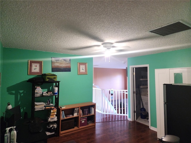 misc room featuring a textured ceiling, dark hardwood / wood-style flooring, and ceiling fan