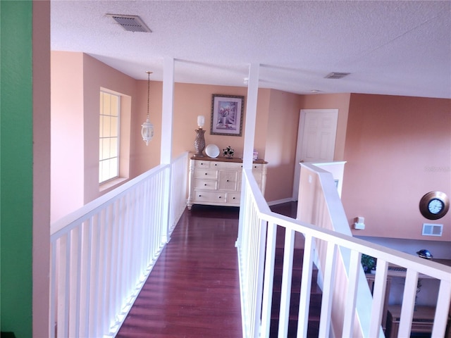 hallway featuring dark hardwood / wood-style floors and a textured ceiling