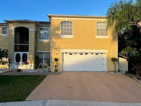 view of front facade featuring a garage, concrete driveway, and stucco siding