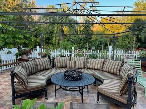 view of patio / terrace featuring fence and an outdoor living space with a fire pit