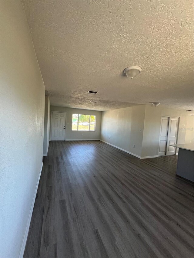 unfurnished room with dark hardwood / wood-style floors and a textured ceiling