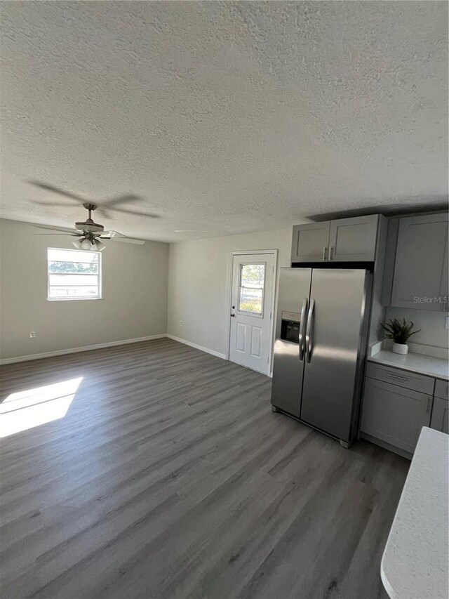 kitchen with gray cabinetry, plenty of natural light, stainless steel fridge, and dark hardwood / wood-style floors