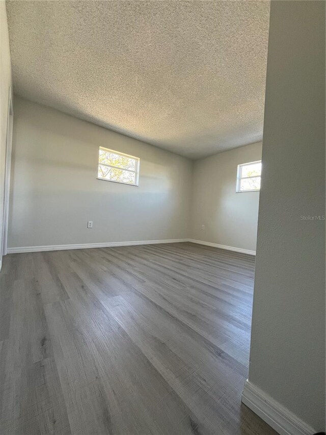 unfurnished room with wood-type flooring and a textured ceiling