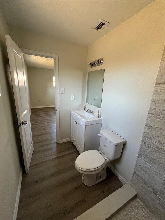 bathroom featuring vanity, hardwood / wood-style flooring, and toilet