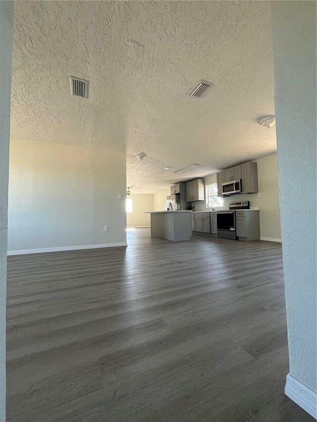 unfurnished living room with dark hardwood / wood-style floors and a textured ceiling