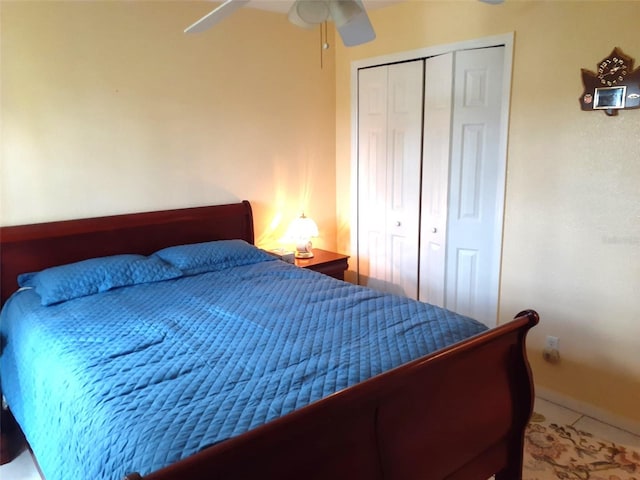 tiled bedroom featuring ceiling fan and a closet