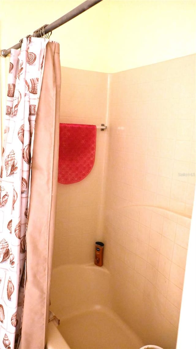 bathroom with shower / bath combination with curtain