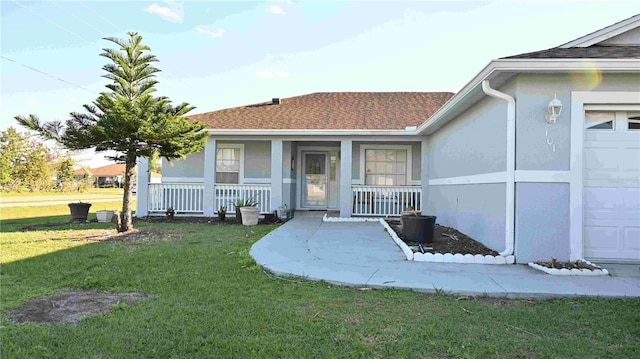 view of exterior entry featuring a yard, a porch, a shingled roof, and stucco siding